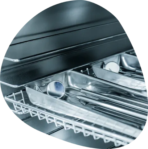 Stainless steel surgical instruments in a wire tray.