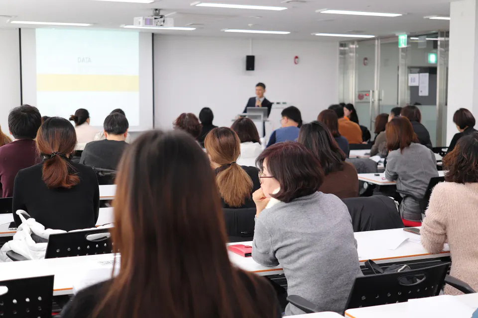 Delegates seated in a training room watching a presenter.